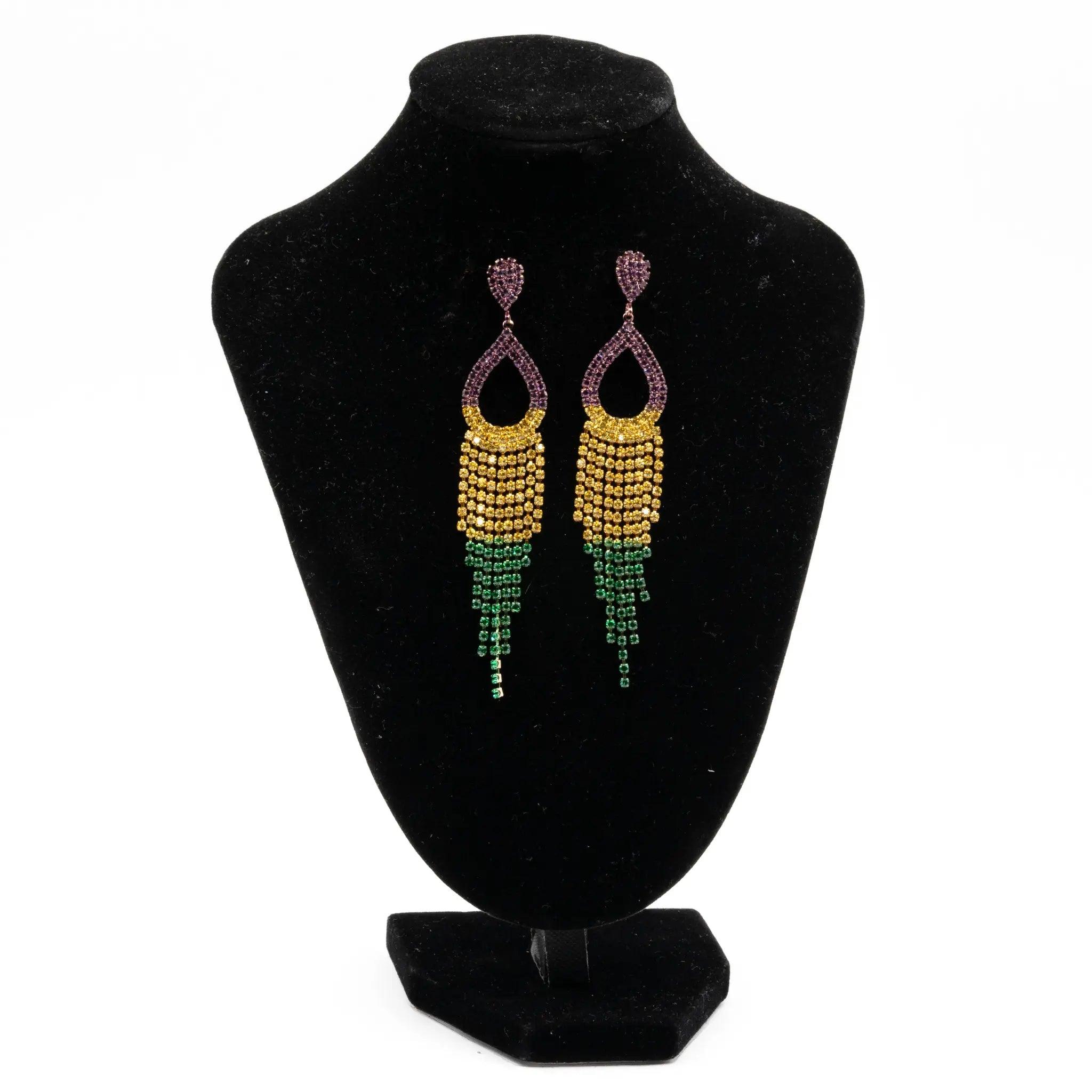 Mardi Gras rhinestone fringe teardrop earrings in purple, green, and gold displayed on a black stand.
