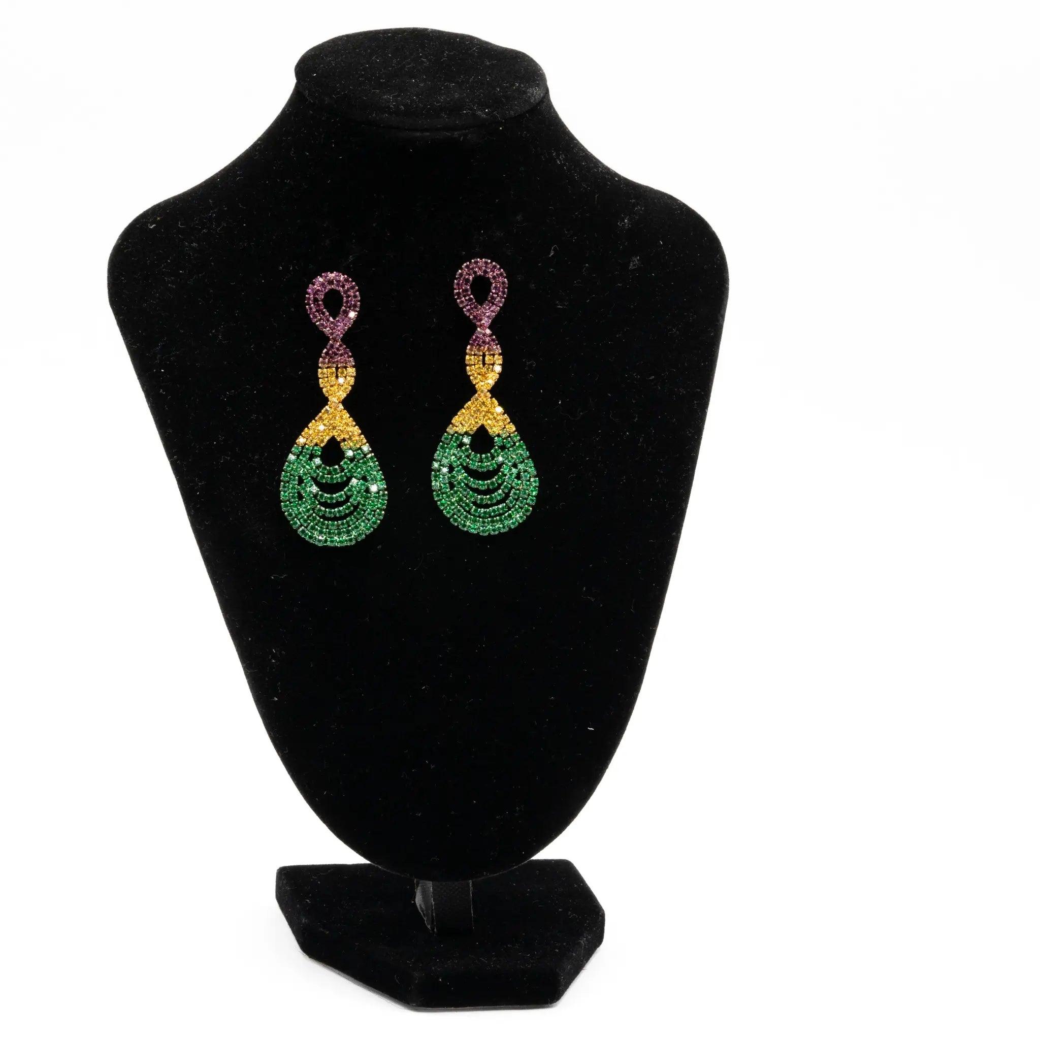 Mardi Gras rhinestone twisted teardrop earrings in purple, green, and gold displayed on a black stand.