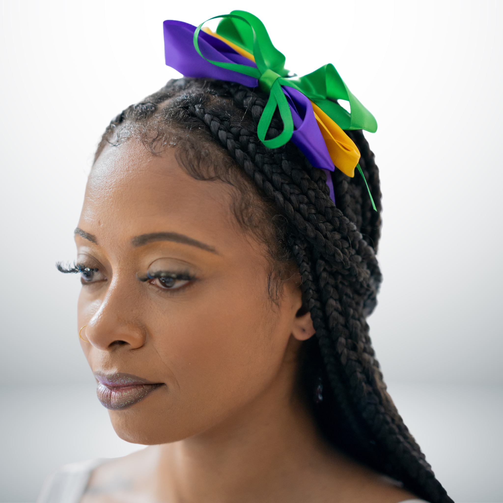 Mardi Gras Triple Ribbon Bow Headband with purple, green, and gold layered ribbons on a braided hairstyle.