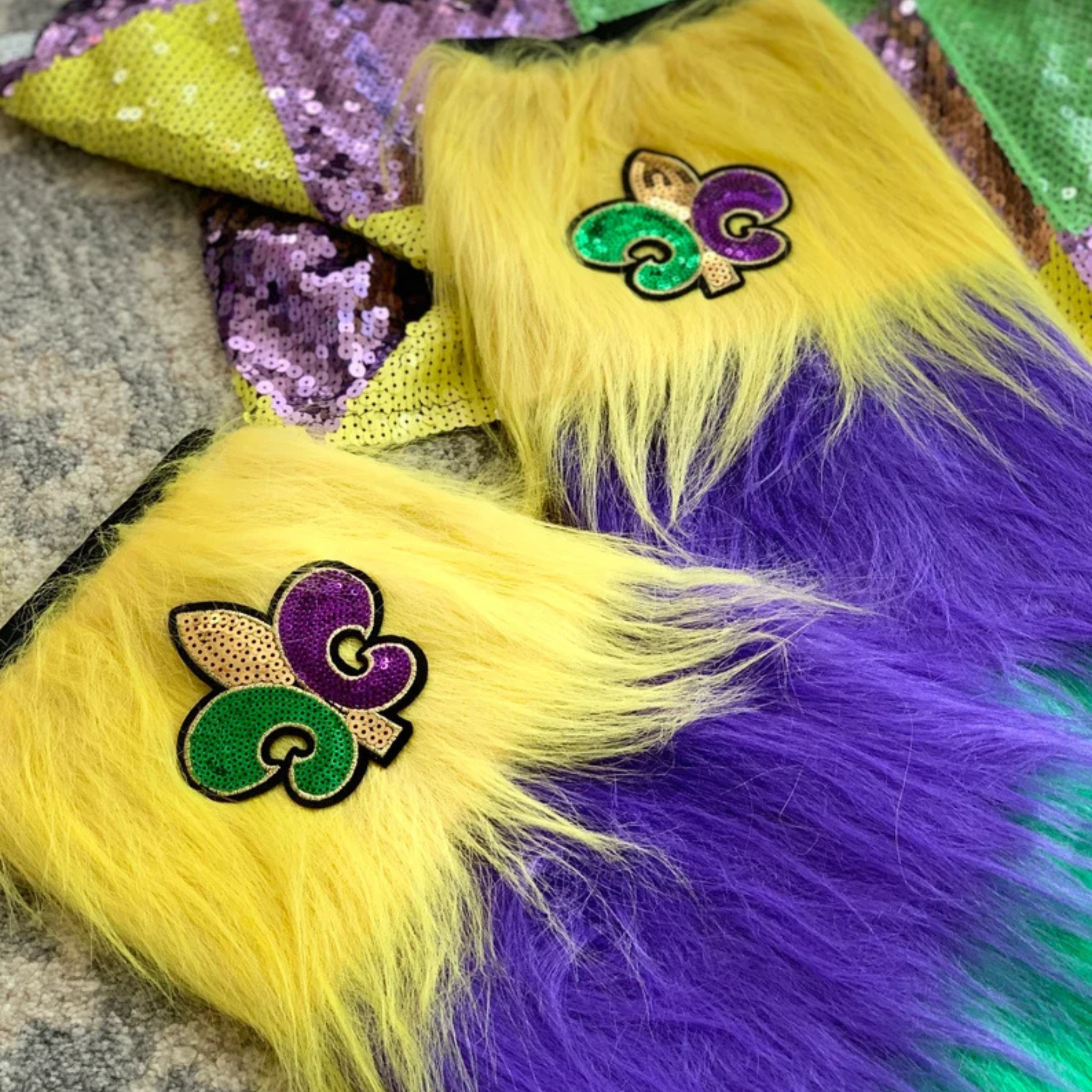 Mardi Gras Furry Leg Warmers with purple, green, and gold stripes, featuring a Fleur-de-Lis patch.