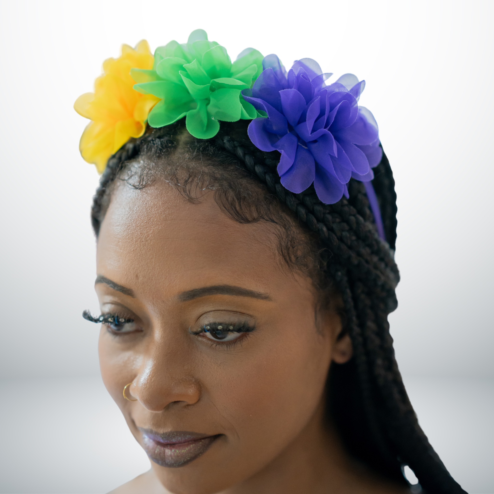 Mardi Gras Floral Headband with purple, green, and gold flowers on a braided hairstyle.