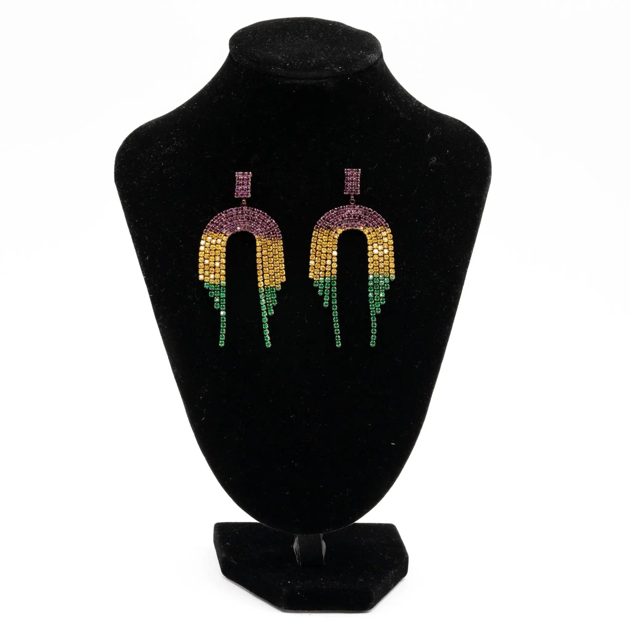 Mardi Gras rhinestone arch drop earrings with purple, green, and gold stones displayed on a black stand.