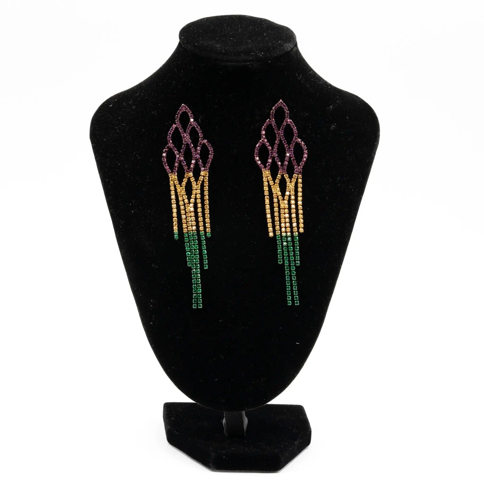 Mardi Gras rhinestone cascade fringe earrings in purple, green, and gold displayed on a black stand.