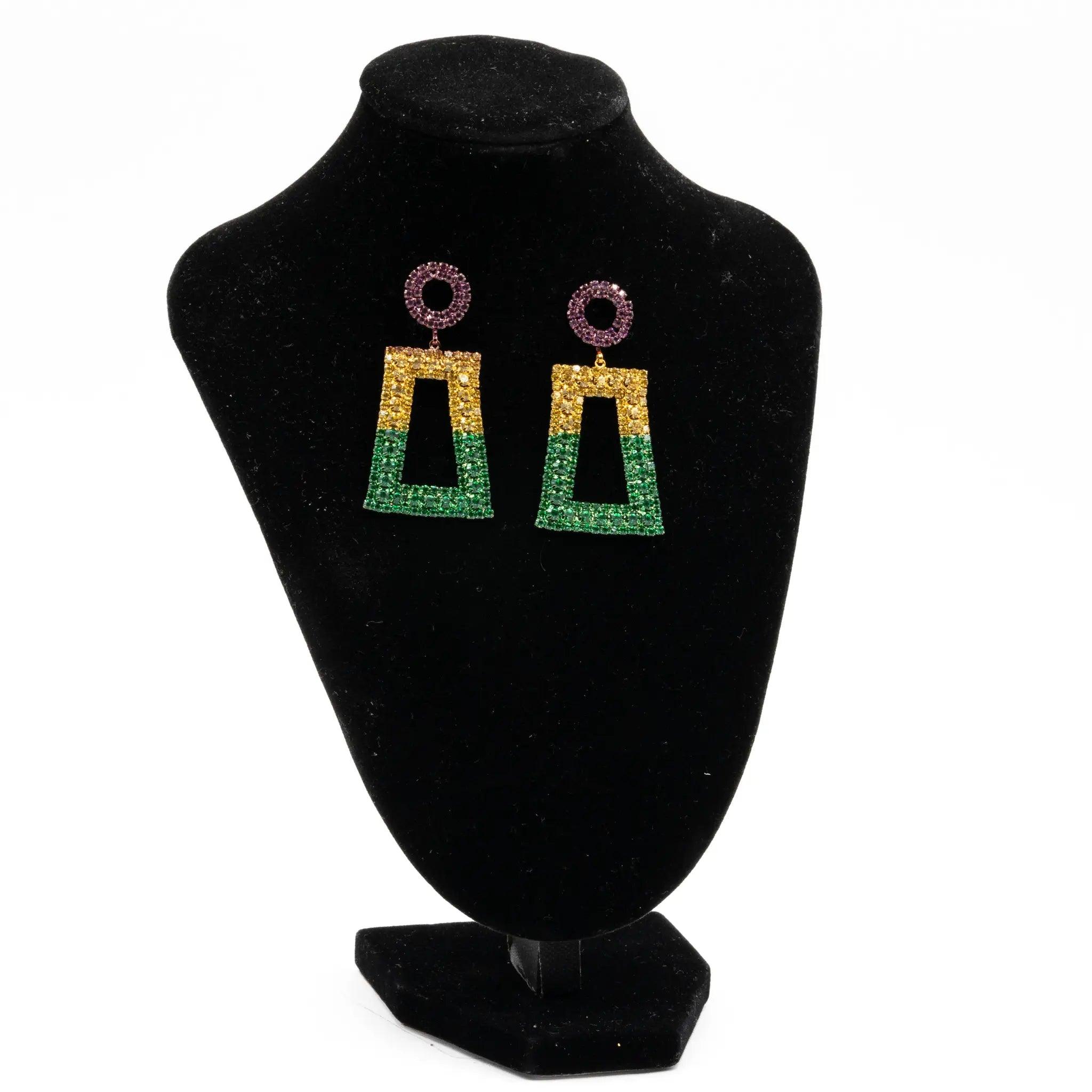 Mardi Gras rhinestone geometric drop earrings in purple, green, and gold displayed on a black stand.